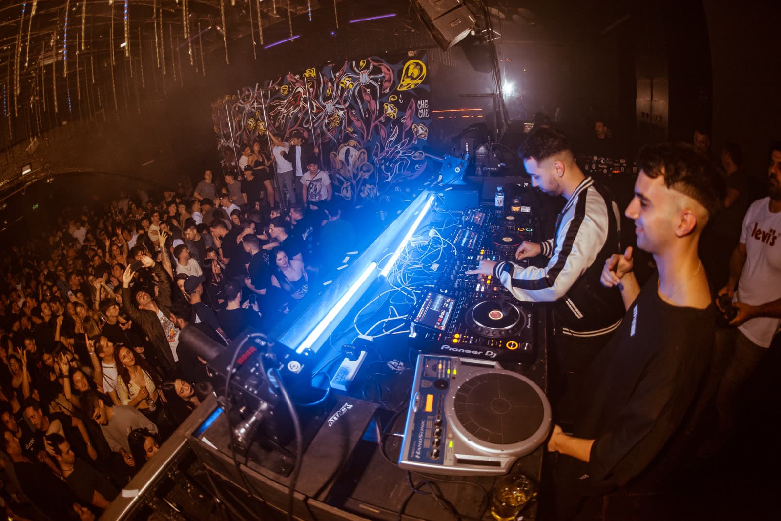 Vista desde la cabina del DJ hacia la pista llena en un evento en CABA